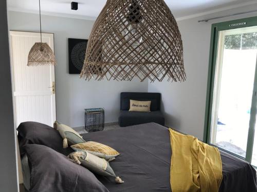 a bedroom with a bed with pillows and a chandelier at Maison Ferruccio in Porto-Vecchio