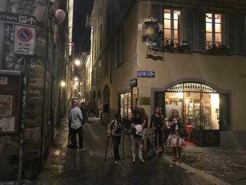 a group of people walking down a street at night at Il Sole in Bergamo