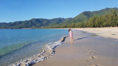 a woman walking on a beach near the water at Aloha Bình Tiên-Thôn Bình Tiên, Công Hải, Thuận Bắc, Ninh Thuận, Việt Nam in Phan Rang