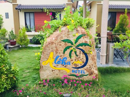 a rock sign with a palm tree on it in a yard at Aloha Bình Tiên-Thôn Bình Tiên, Công Hải, Thuận Bắc, Ninh Thuận, Việt Nam in Phan Rang