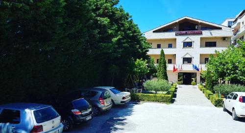 a group of cars parked in front of a building at Hotel Ambasador Garden in Lezhë
