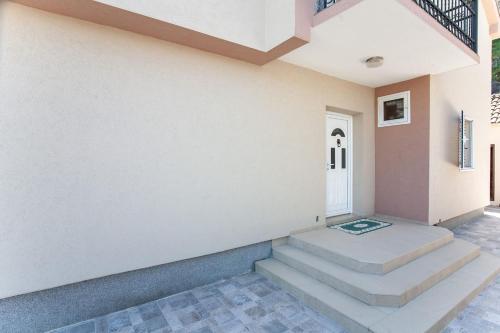 a room with stairs and a white wall at Luxury House Petrovic - Vranjina Skadar Lake in Podgorica
