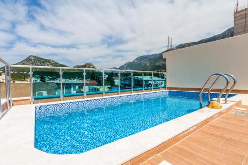 a swimming pool on the roof of a building with mountains in the background at Villa Jadranka Sutomore in Sutomore
