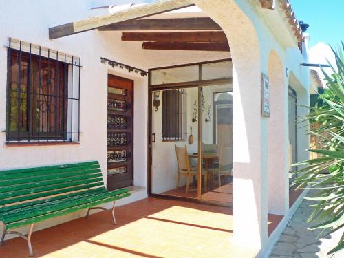 un banco verde sentado fuera de una casa en Holiday Home Marinada by Interhome, en L'Ampolla