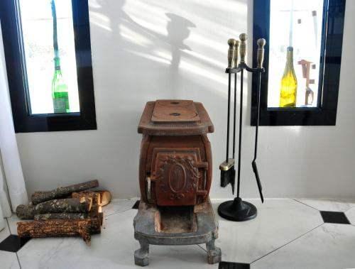 an old wood stove in a room with two windows at Şato Design Hotel in Cesme