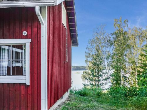 a red building with a window next to a lake at Holiday Home Punasotka 2 by Interhome in Strandby