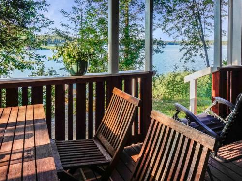 two benches on a porch with a view of the water at Holiday Home Rantasipi 1 by Interhome in Strandby