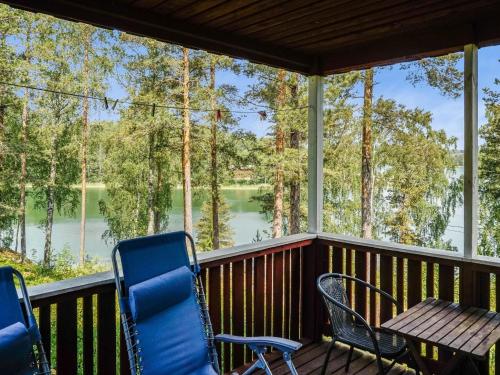 a porch with chairs and a table and a view of a lake at Holiday Home Kalatiira 3 by Interhome in Strandby