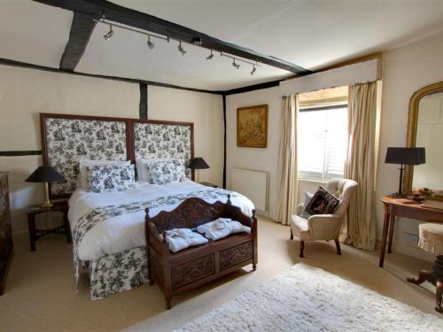 a bedroom with a large bed and a chair at Holiday Home Strand Street by Interhome in Sandwich