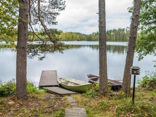 un pequeño barco sentado junto a un muelle en un lago en Holiday Home Jukola by Interhome, en Ruottila