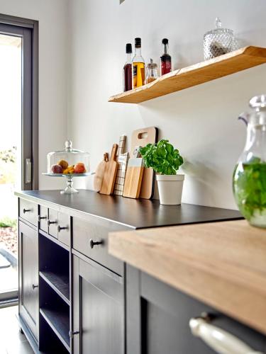 a kitchen with a black counter top and a shelf at AU LOGIS DE BELLEFOIS - Chambres d'hôtes in Neuville-de-Poitou