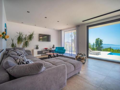 a living room with a large couch and a large window at Villa Minimal by Interhome in Kastav