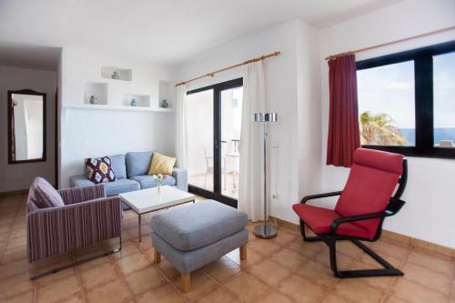 a living room with a couch and a chair at Costa Luz Beach Apartments in Puerto del Carmen