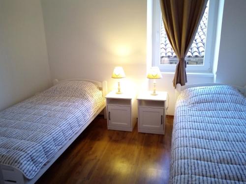 two twin beds in a bedroom with a window at Rosemary Apartment in Koper