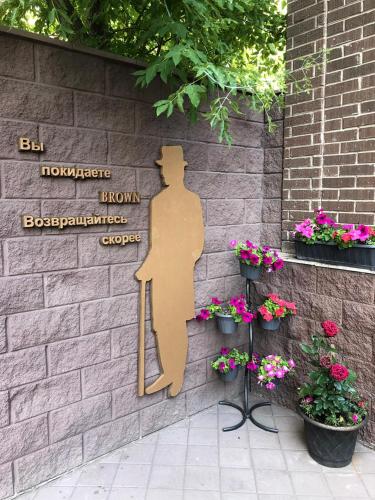 a sign on the side of a brick wall with flowers at Brown Hotel in Astana