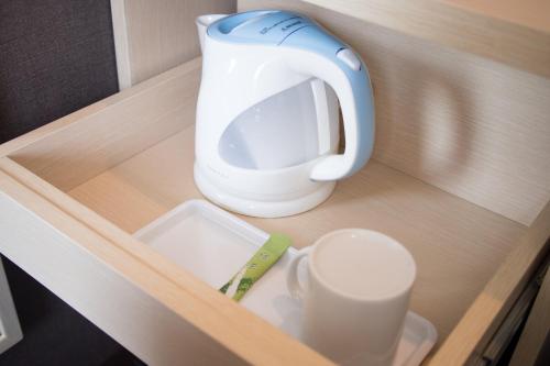 a tea pot and cups on a wooden shelf at Super Hotel Tokyo JR Shinkoiwa in Tokyo