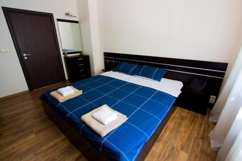 維丁的住宿－Modern Apartment in the Heart of Vidin，一间卧室配有蓝色的床和2条毛巾