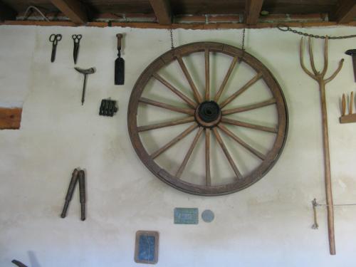 a wall with a wooden wheel and tools on it at Casa Rural Arturo I in Sahagún