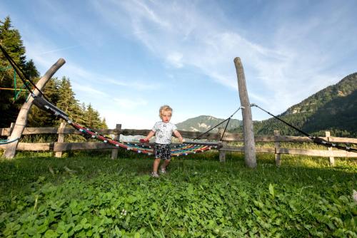 a little boy standing in front of a fence at Hotel Pinei in Ortisei