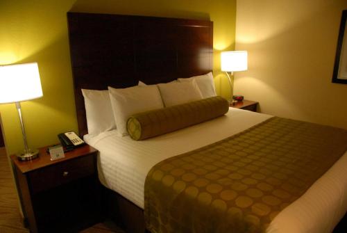 a hotel room with a large bed with two lamps at Cobblestone Inn & Suites - Marquette in Marquette