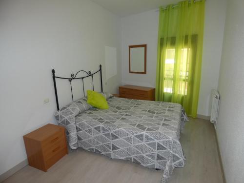 a bedroom with a bed with a yellow pillow on it at APARTAMENTOS DAYMA in Jarandilla de la Vera