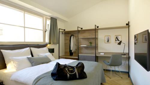 a bedroom with a bed with a black purse on it at Hotel Maribor & Garden Rooms in Maribor