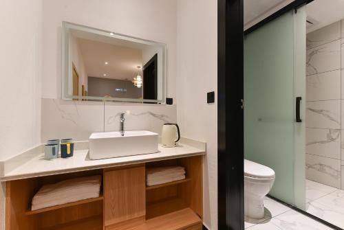 a bathroom with a sink and a toilet at Yifangyan - Tingyuan Qingshe Hostel in Fenghuang