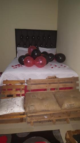 a bed with red and black balloons on it at Lapa la Bakgatlha in Soweto