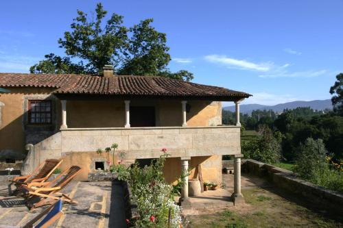 ein Haus mit einer Veranda und Stühlen davor in der Unterkunft Quinta Da Agra in Ponte de Lima