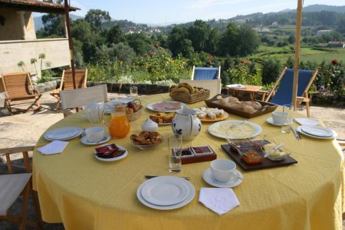 a table with a yellow table cloth with food on it at Quinta Da Agra in Ponte de Lima