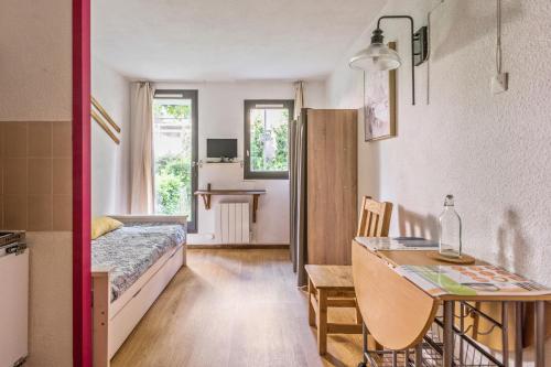 シャモニー・モンブランにあるResidence L'Aiguille - maeva Homeのベッドとダイニングテーブル付きの小さな部屋です。