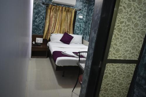 a small room with a bed and a window at Hotel Arma Court - Near US Embassy, BKC in Mumbai