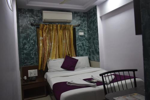 a small bedroom with a bed and a window at Hotel Arma Court - Near US Embassy, BKC in Mumbai