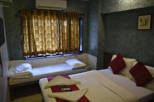 sypialnia z 2 łóżkami i oknem w obiekcie Hotel Arma Court w Bombaju