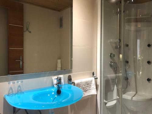 a bathroom with a blue sink and a shower at Hostal Piteus in Sant Llorenc de Morunys