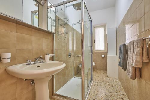 bagno con lavandino e doccia in vetro di Marciana Hills Apartments a Marciana