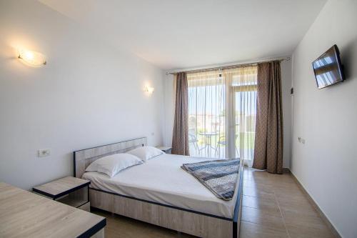 a bedroom with a bed and a large window at Sea View Vama Veche in Vama Veche