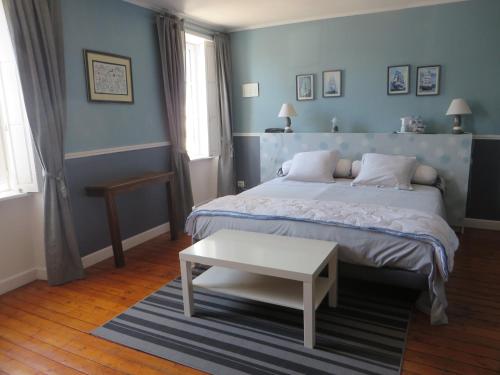 a blue bedroom with a bed and a table at Chambres d'Hôtes de la 101ème in Carentan