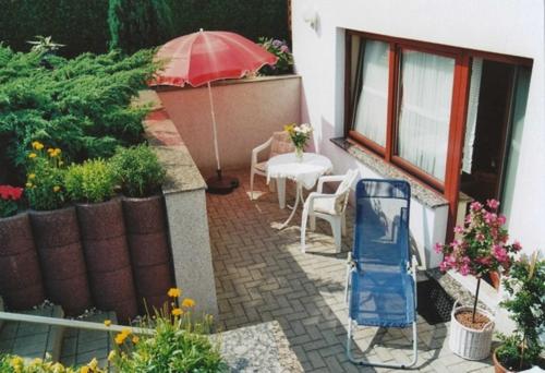 eine Terrasse mit einem Sonnenschirm, einem Tisch und Stühlen in der Unterkunft Ferienunterkünfte Wießmann in Heringsdorf