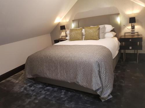 a hotel room with a large bed with pillows at The Queens Head, Parkside apartment 2 in Burley in Wharfedale