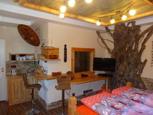 a bedroom with a bed and a desk with a tree on the wall at Resort Svět in Úžice