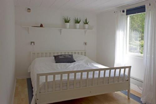 Habitación blanca con cama y ventana en Stora Timrarö Unwind, en Vadholma