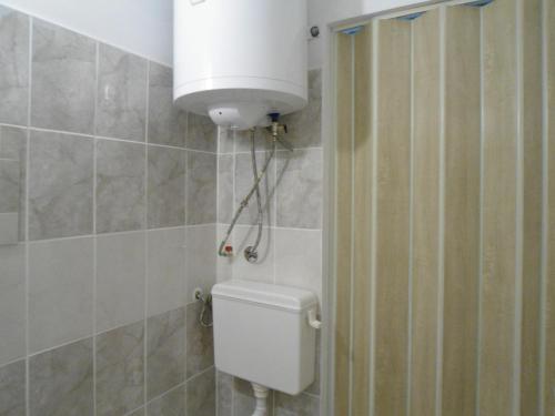 a bathroom with a toilet with a water tank at Граничар 3 СЪРФА in Granichar