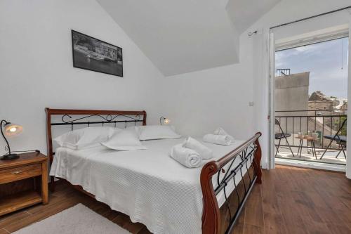 Schlafzimmer mit einem Bett mit weißer Bettwäsche und einem Fenster in der Unterkunft Luxury Villa Topolina in Baška Voda