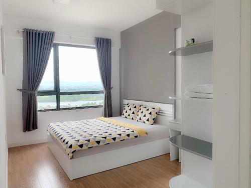 a bedroom with a bed and a large window at MRT Apartment In Masteri Thao Dien in Ho Chi Minh City