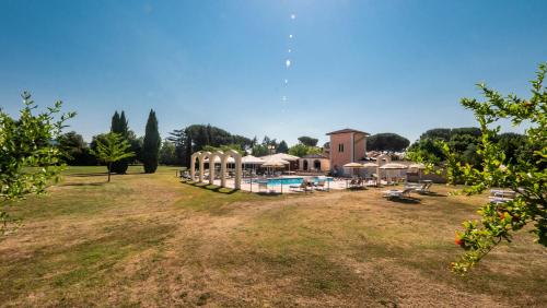 een grote tuin met een zwembad en een gebouw bij Hotel Vega Perugia in Perugia