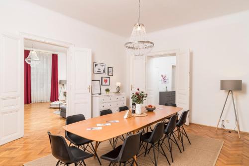 a dining room with a large wooden table and chairs at Rainer Maria Rilke Suite in Vienna