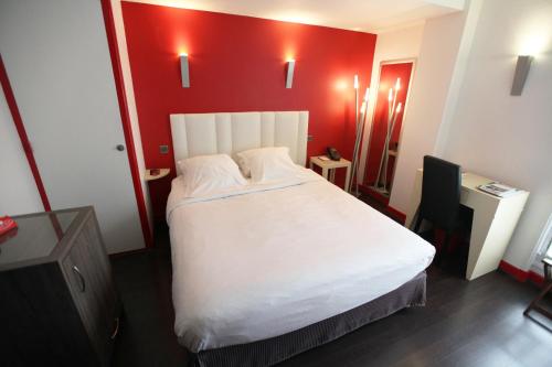 a bedroom with a white bed with a red wall at Les Maritonnes Parc & Vignoble in Romanèche-Thorins