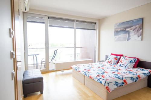 a bedroom with a bed and a large window at City center apartment Aida in Pärnu