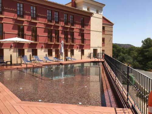 a hotel with a swimming pool in front of a building at Jardines de La Santa in Totana